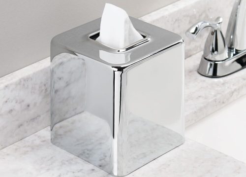 A metal tissue box placed near the sink in the bathroom.